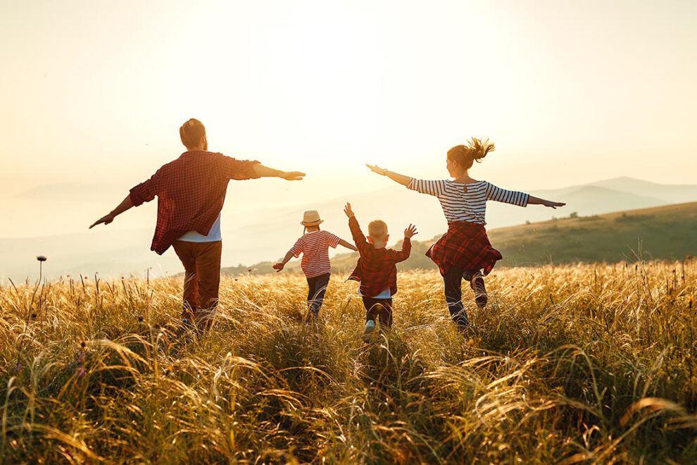 Happy family: mother, father, children son and daughter on sunset