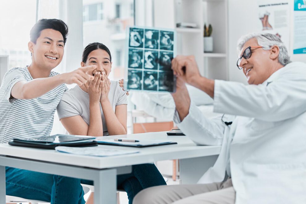 Shot of a young couple celebrating their pregnancy while sitting with their obstetrician in the clinic